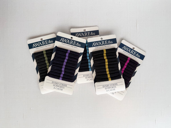 Packaged hairties with 'AWAREties' labels on a gray background