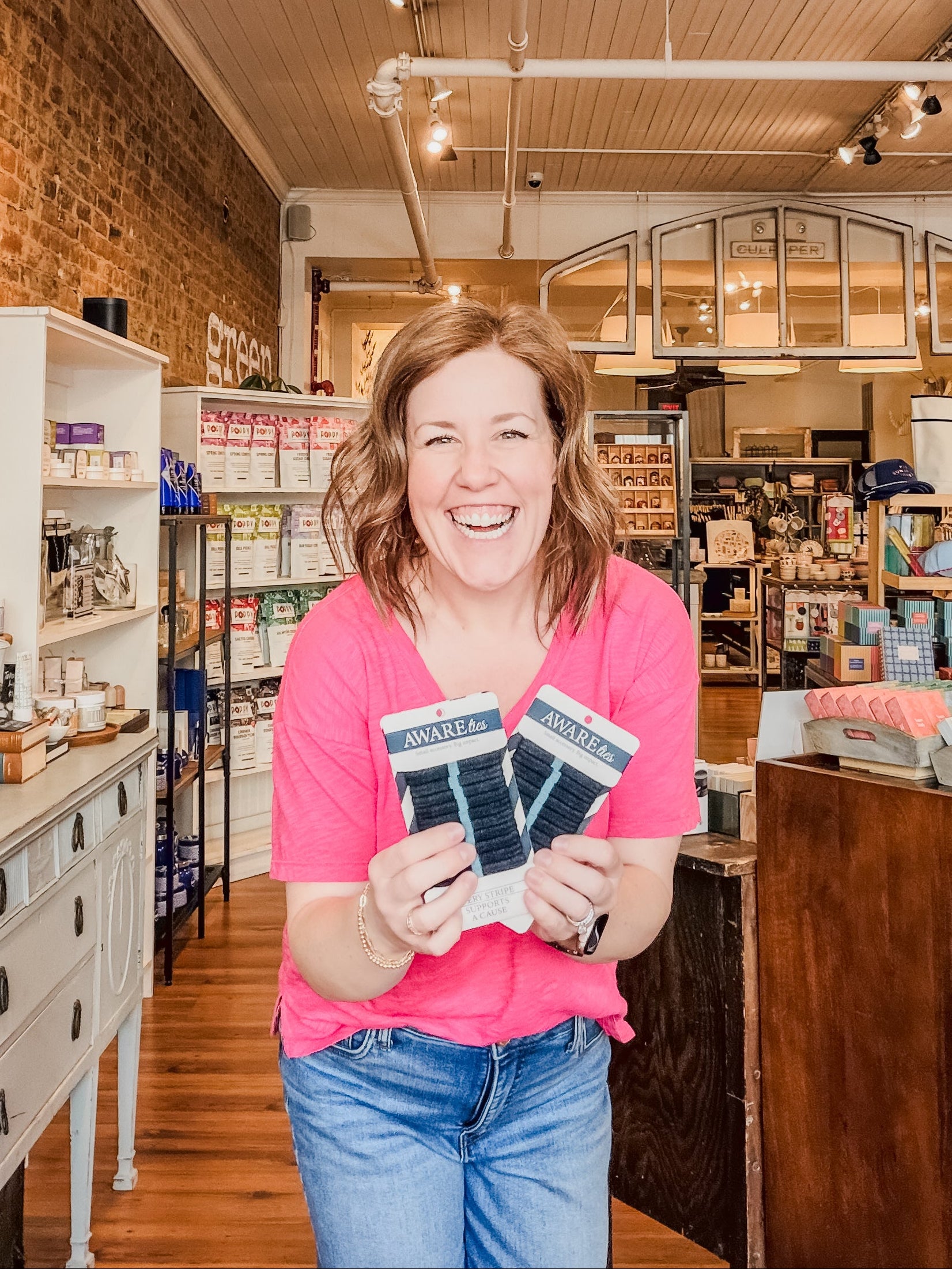 Woman holding socks in a store with brick walls and wooden floors