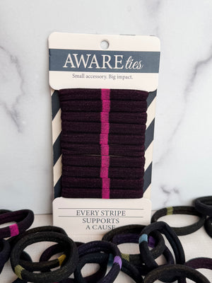 Packaged hair ties with visible branding on a marble surface