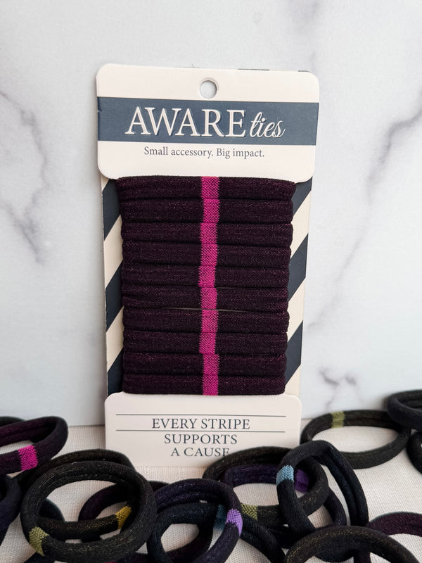 Packaged hair ties with visible branding on a marble surface