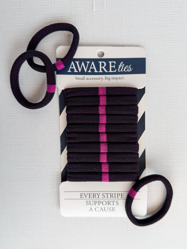 Black hair ties with pink stripes on a 'Aware' branded card against a white background