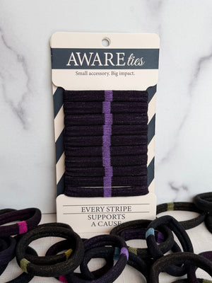 Packaged hair ties with visible brand 'Aware' on a marble surface