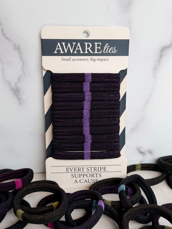 Packaged hair ties with visible brand 'Aware' on a marble surface