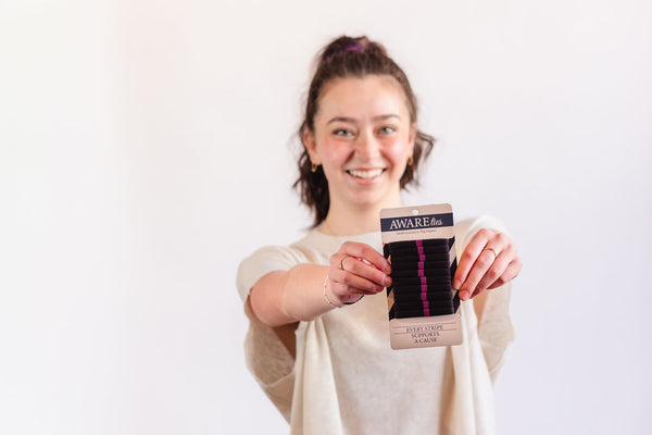 Person holding a product with 'Aware' branding against a white background